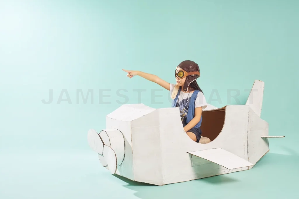 
A young girl plays pilot sitting in her self-made cardboard airplane