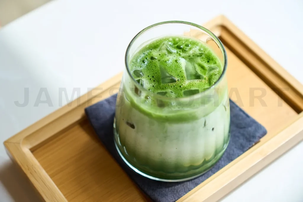 
Iced matcha green tea latte sitting on wooden tray