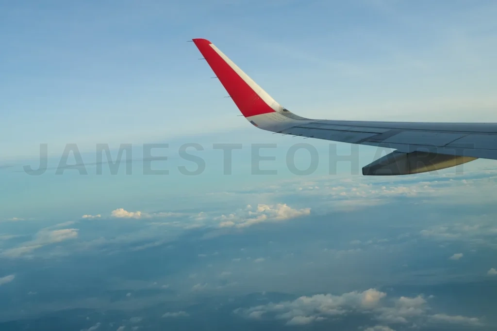 
Airplane wing soaring above the clouds during a flight over the