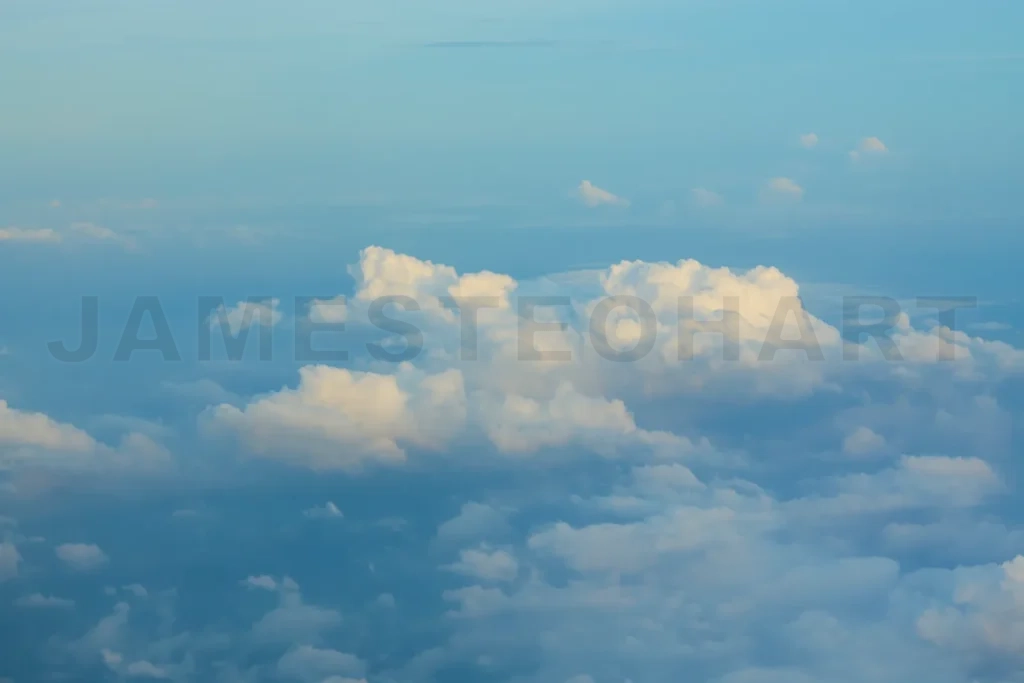 
White clouds are forming above the horizon in a blue sky
