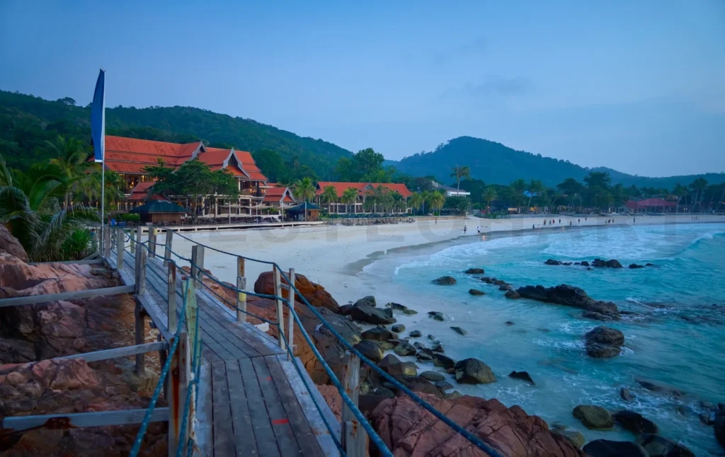 
Wooden walkway leading to beach resort at twilight in redang island