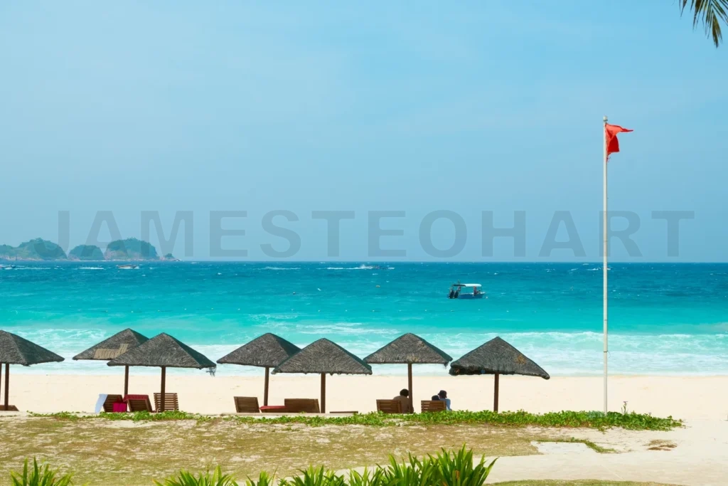 
Tourists relaxing under thatched umbrellas on redang island beach