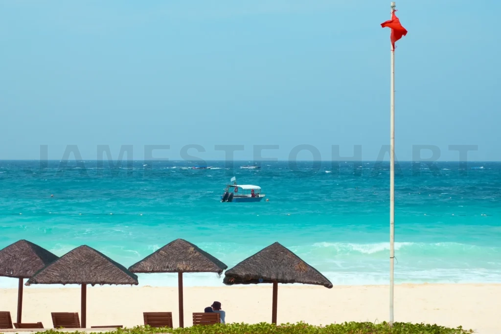 
Couple enjoying tropical paradise beach with red warning flag