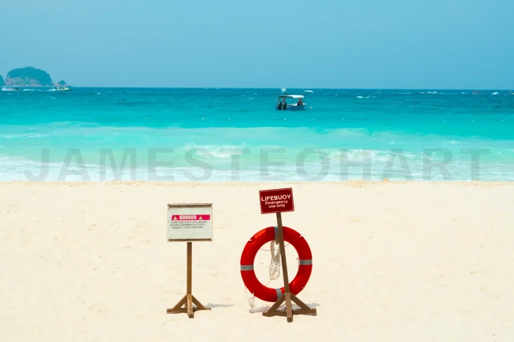 
Lifebuoy and danger sign standing on a tropical beach