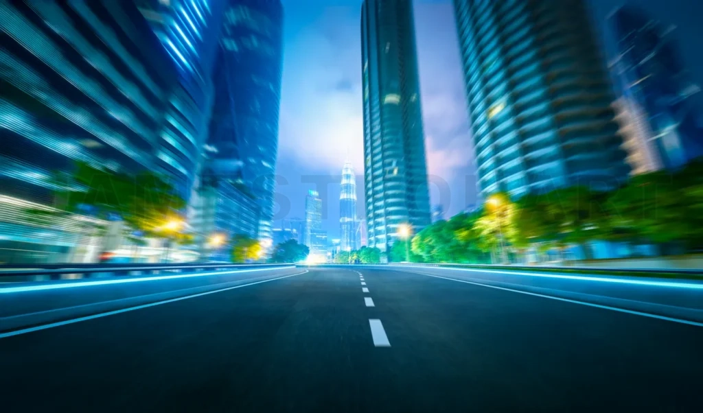 
Speeding through illuminated city with modern skyscrapers at dus