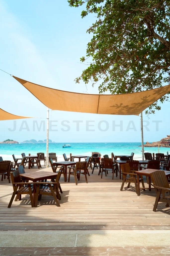 
Wooden beach bar restaurant tables and chairs standing on a tropical beach