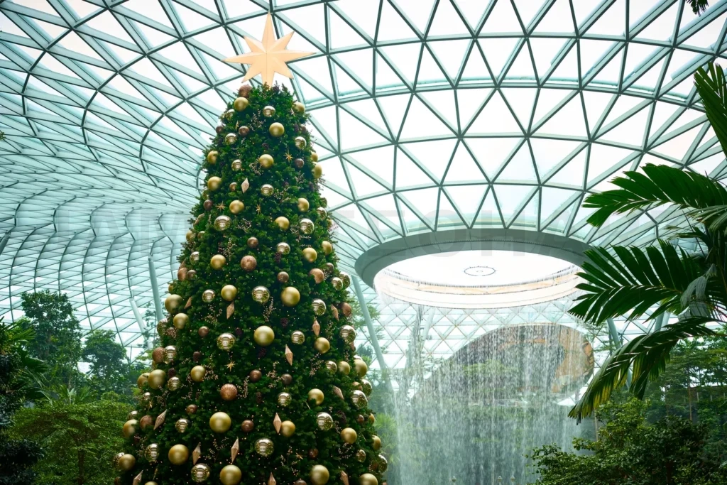 
Christmas tree standing tall under glass dome with waterfall in jewel changi airport