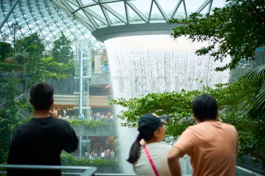 
Tourists admiring the rain vortex waterfall at jewel changi airport