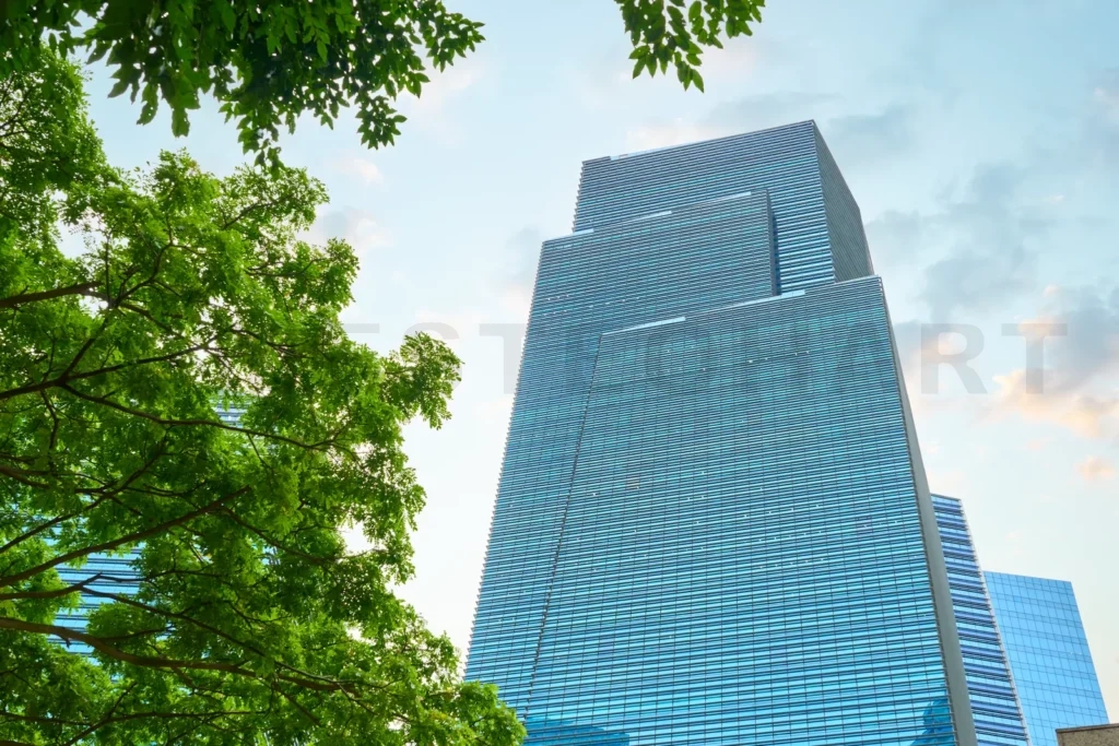 
Modern skyscraper towering amidst lush greenery
