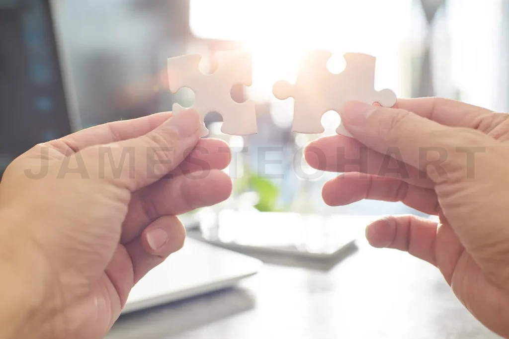 
Young Businessman Trying To Connect Couple Puzzle Piece With Sun Flare And Blur Background,Symbol Of Association And Connection