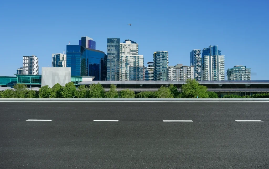
Empty asphalt road paving way to modern city skyline