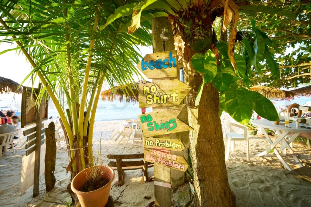 
Wooden sign with beach rules in tropical setting