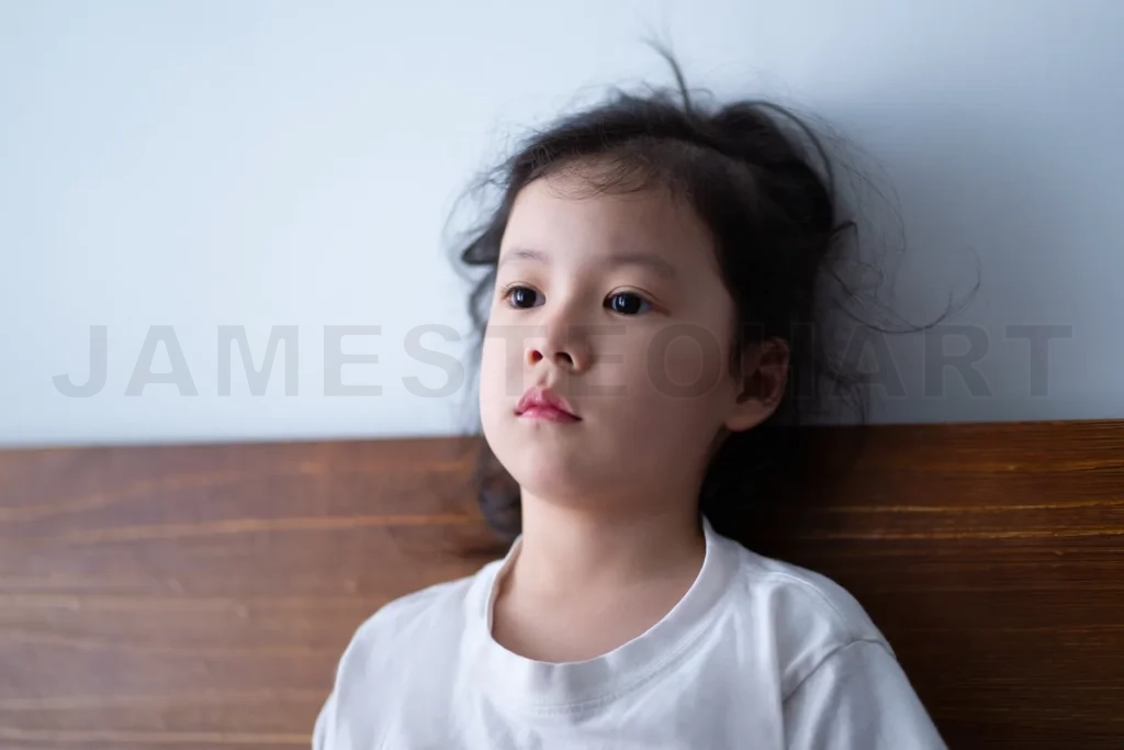 
Sad child sitting on wooden chair and thinking