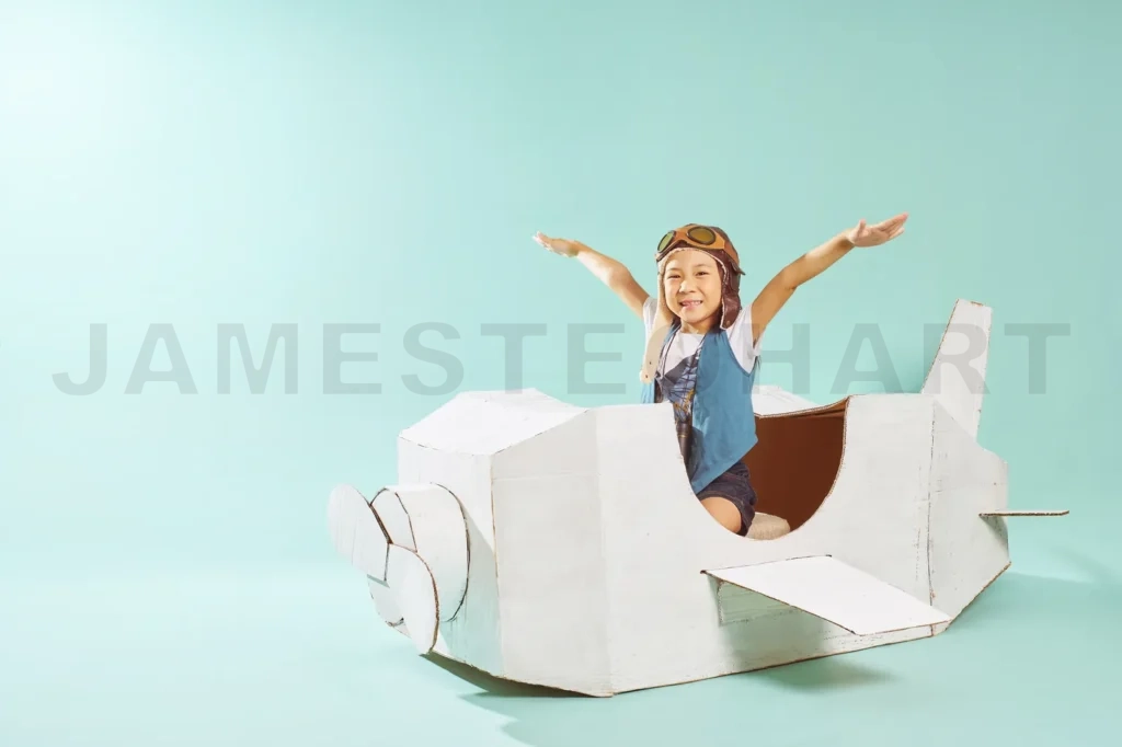 
Little Cute Girl Playing With A Cardboard Airplane