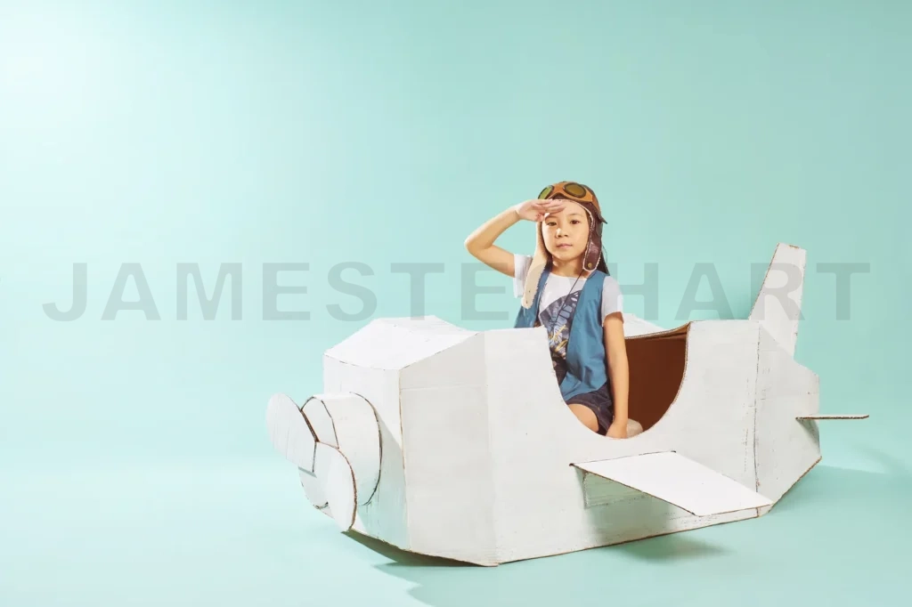 
Little Cute Girl Playing With A Cardboard Airplane