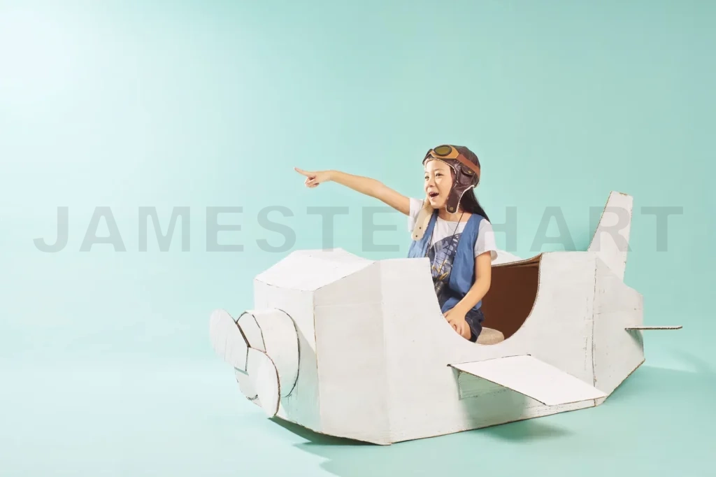 
Little Cute Girl Playing With A Cardboard Airplane