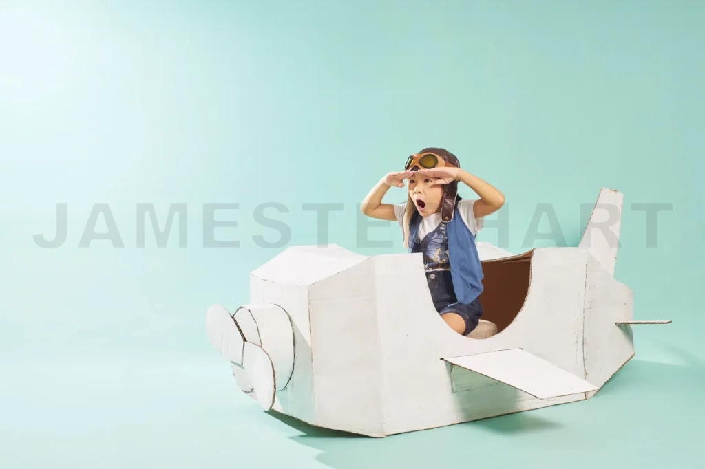 
Little Cute Girl Playing With A Cardboard Airplane