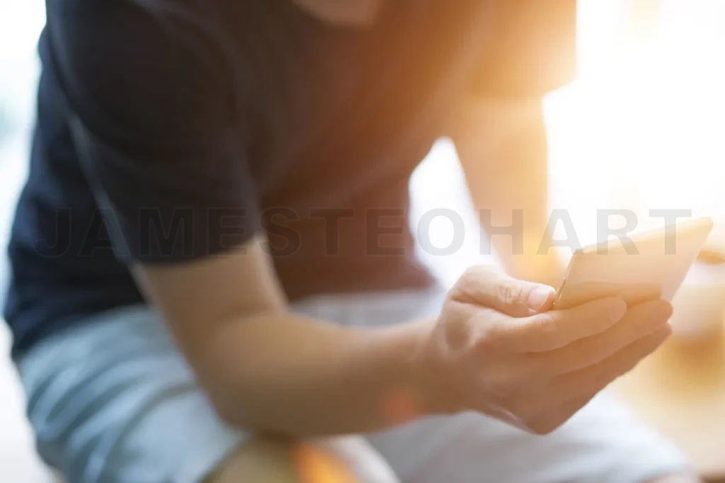 
Closeup Of Young Man Using Smartphone With Sun Flare