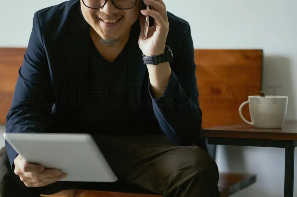 
Closeup Of Businessman Using Smartphone And Digital Tablet