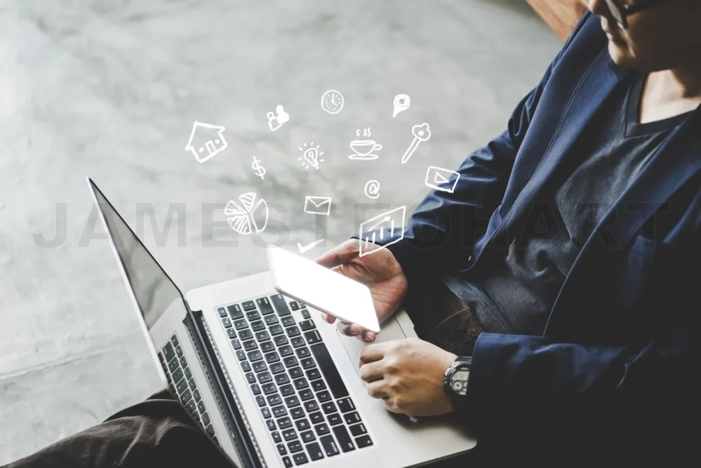 
Businessman using laptop and smartphone with emerging business icons