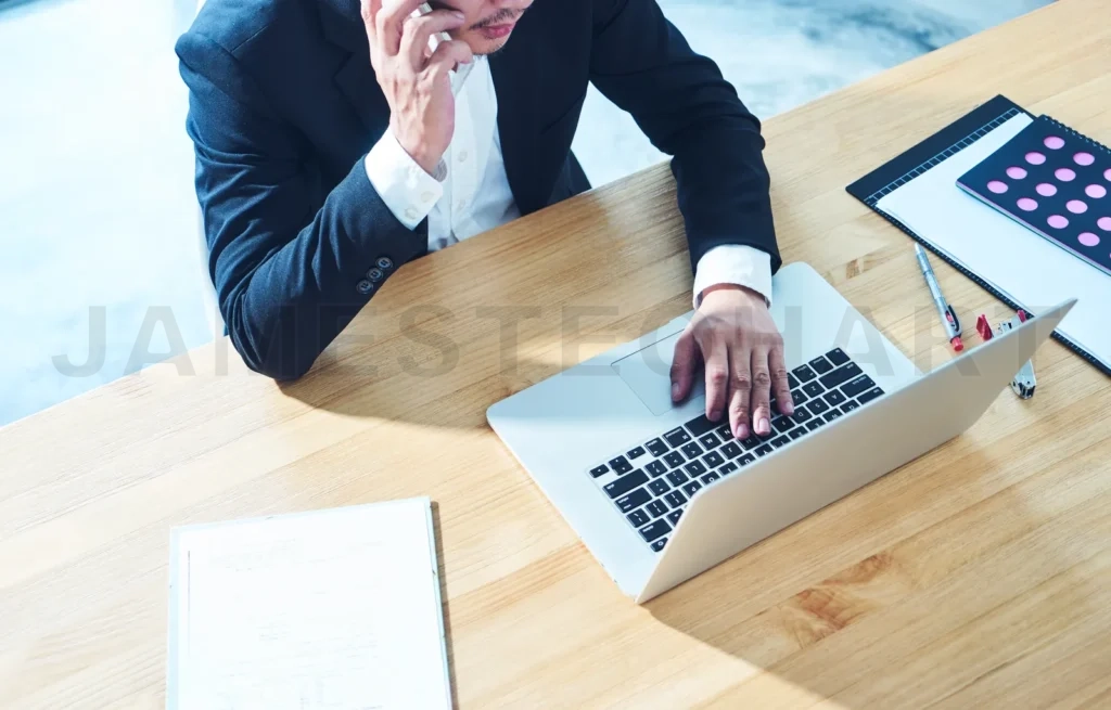 
Top Angle View Of Businessman Using Smart Phone And Laptop  To Working At Office