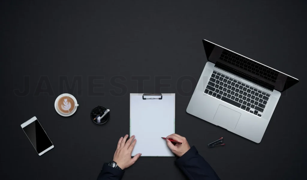 
Person writing on clipboard at organized desk workplace