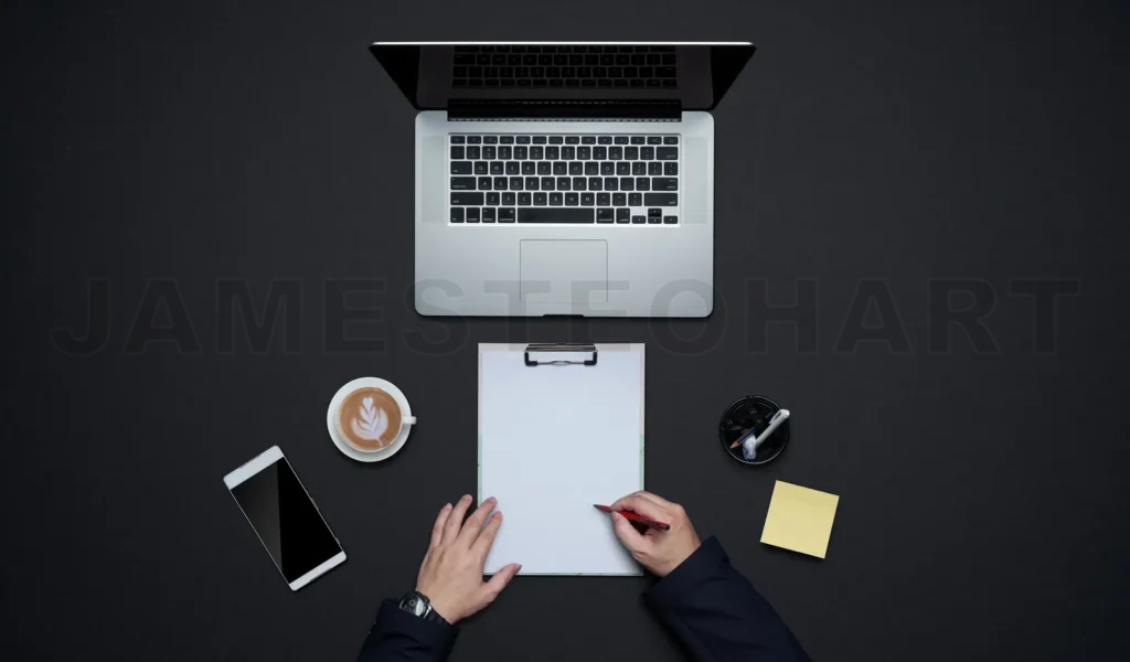 
Person writing notes on clipboard at modern workspace