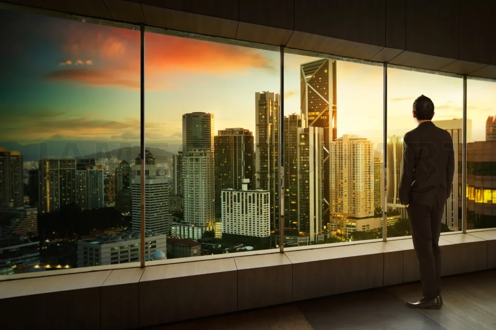 
Businessman Looking And Thinking Front Of A Window Office With Modern City Skyline