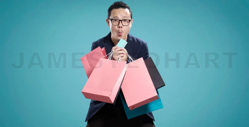 
Excited shopper kissing credit card and holding shopping bags on turquoise background