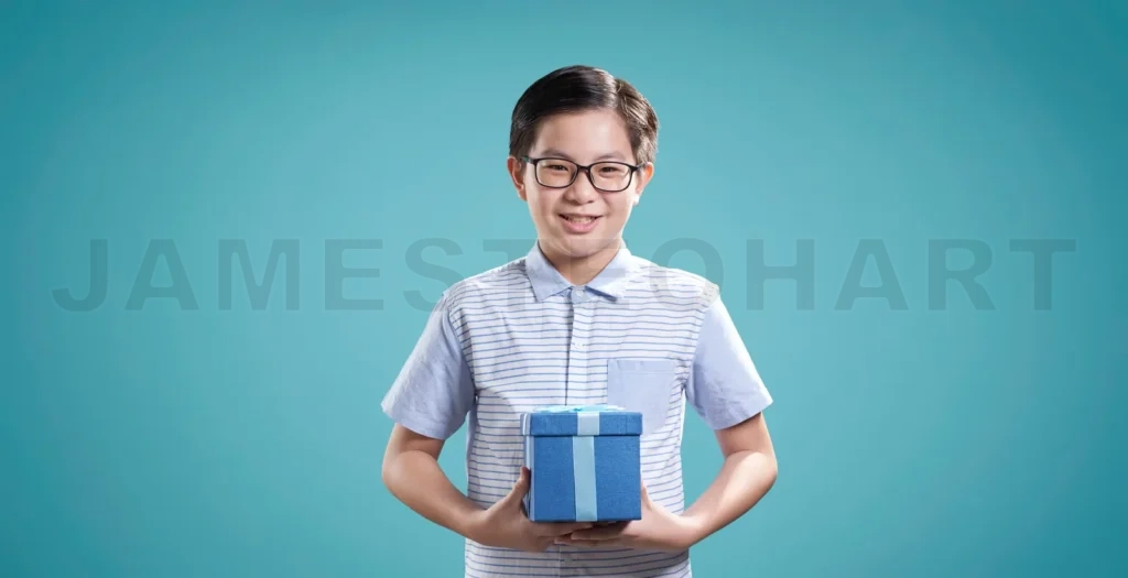 
Smiling boy holding a gift on blue background