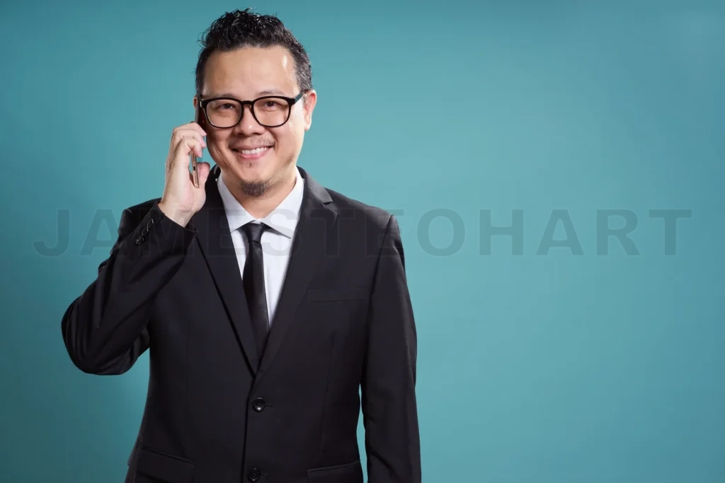 
Portrait Of Asian Businessman Smile And Using Smartphone On Vintage Blue Background