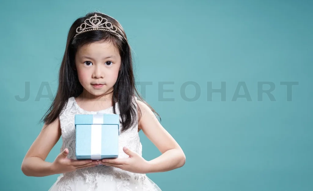 
Close Up Portrait Of Asian Little Happy Girl With Blue Present Box , Isolated On Light Blue Background