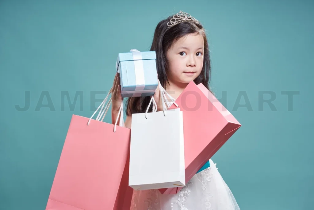 
Portrait Of Little Asian Beautiful Girl Holding  Present Box And Shopping Bag On Vintage Blue Background