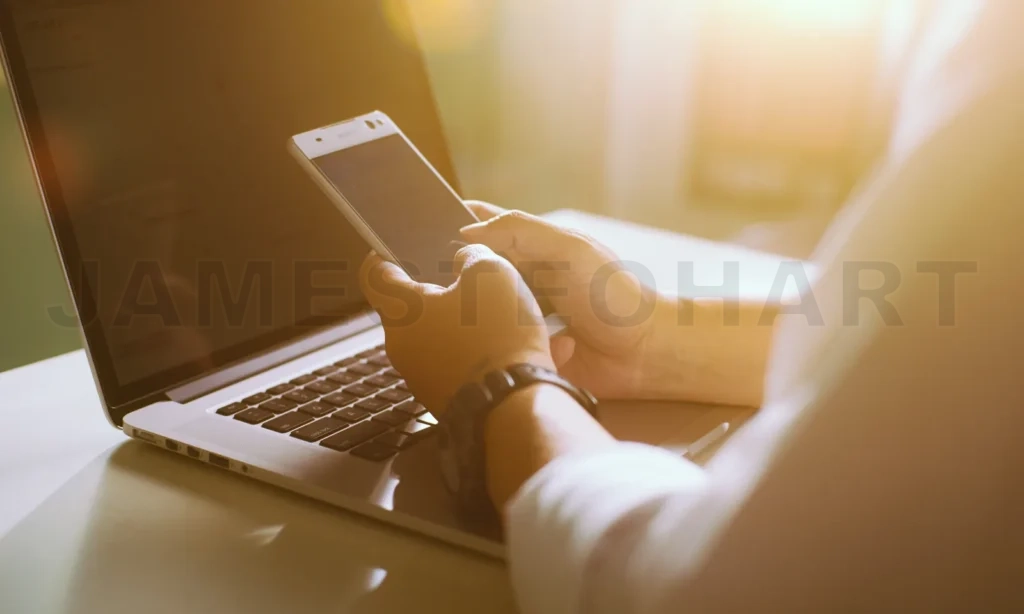 
Silhouette Of Cropped Shot Of A Young Man Working From Home Using Smart Phone