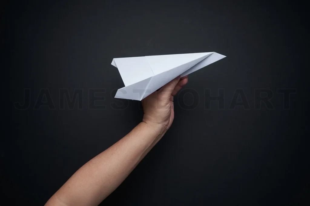 
Hand launching paper plane creating new ideas