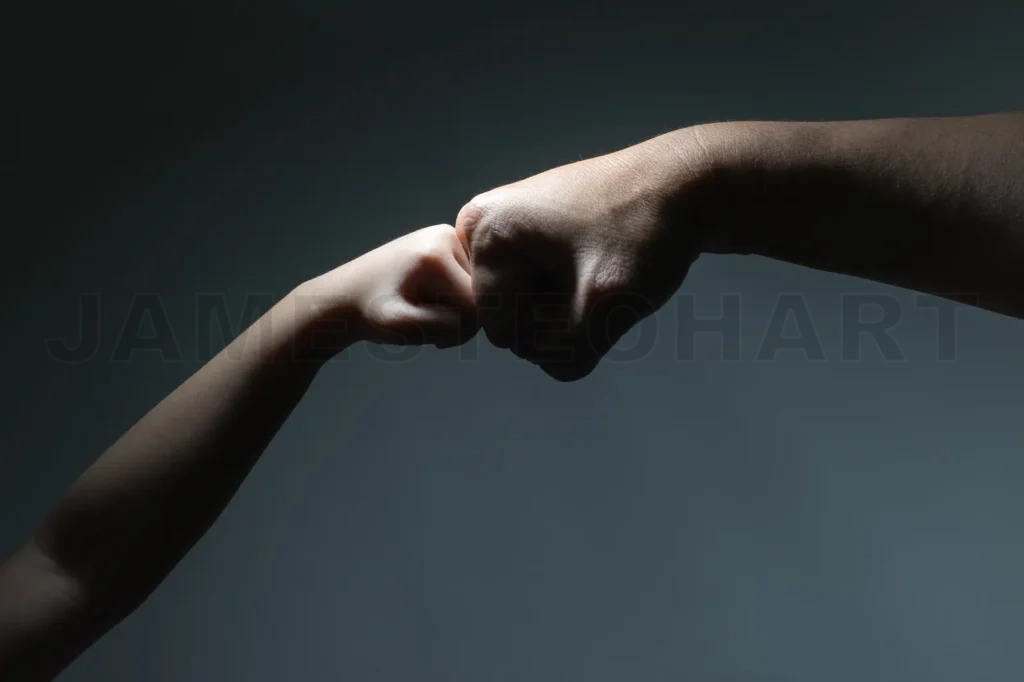 
Closeup Of Two Touching With Punches Hands Of Kid And Male Father As Symbol Of Family Love And Trust On Black Background