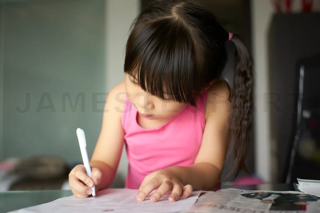 
Asian girl studying learning writing homework at home