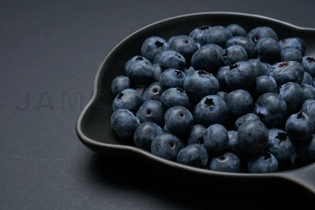 
Fresh blueberries in black bowl on dark background