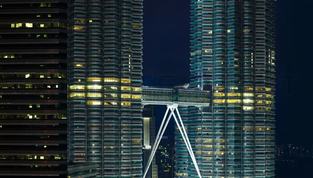 
Skybridge connecting two illuminated skyscrapers at night in kua