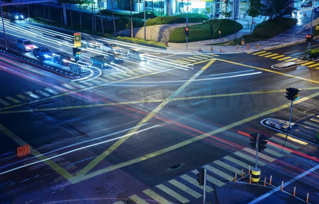 
A High Angle View Of  Treet Intersection, With Yellow Cross Walk Markings, Traffic Signal Lights, And Curb Cuts
