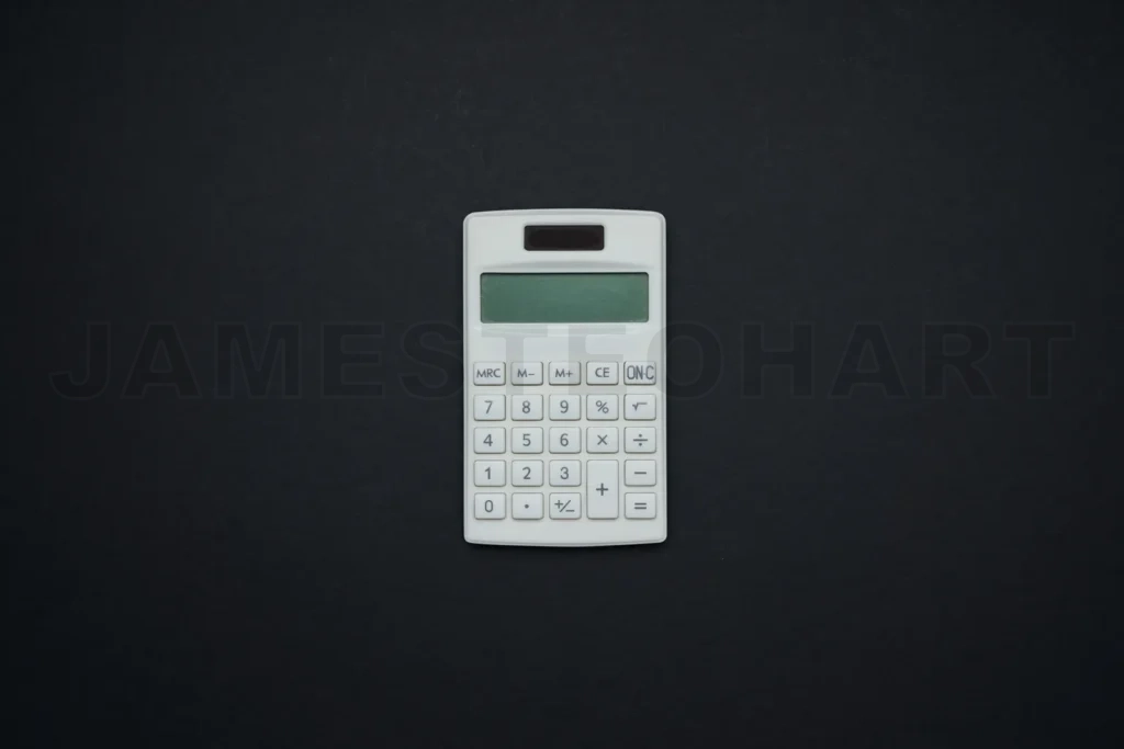 
White calculator calculating finances on black background