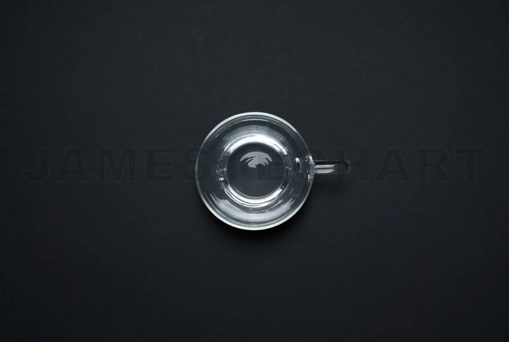 
Empty clear glass cup on black background top view