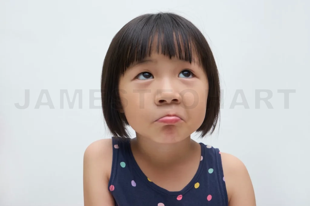 
Little girl making thinking face looking up on white background