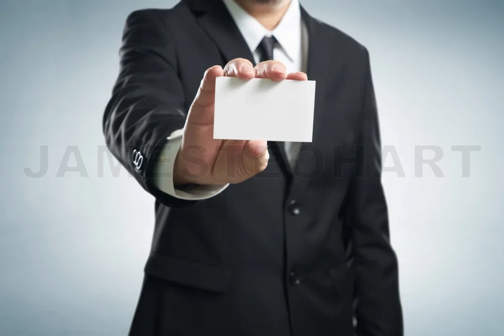 
Man’s hand showing business card – closeup shot on grey backgrou