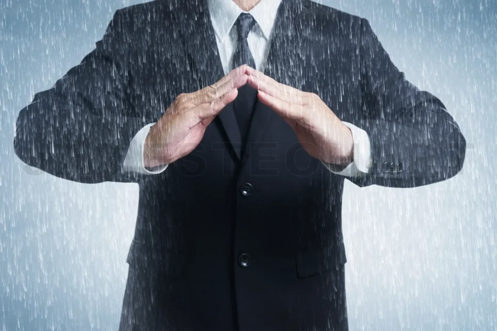 
Businessman In Suit With Two Hands In Position To Protect In Rainy Weather Day (Focus On Hand, Blur Out The Suit)