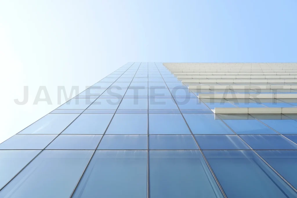 
Modern skyscraper glass facade reaching clear blue sky