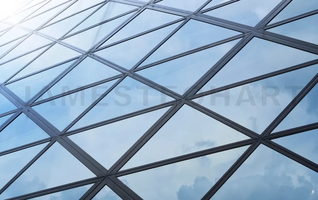 
Modern building glass facade reflecting blue sky and clouds