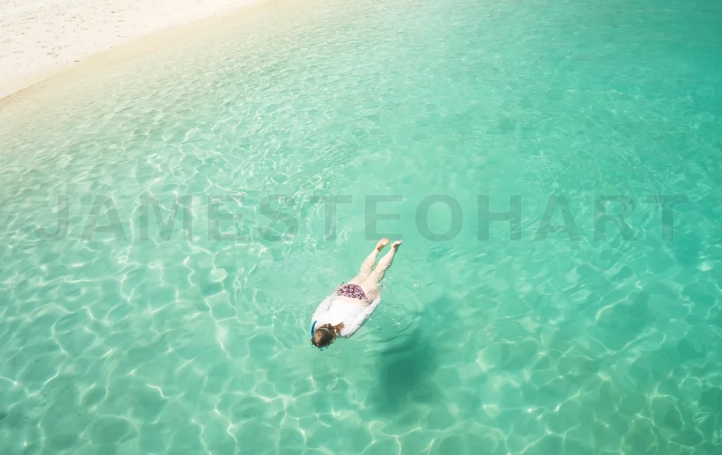 
Woman swimming in clear turquoise ocean water