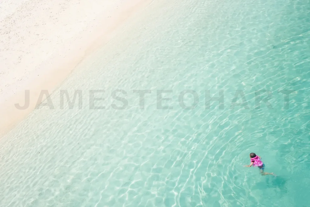 
Child swimming enjoying clear turquoise ocean water