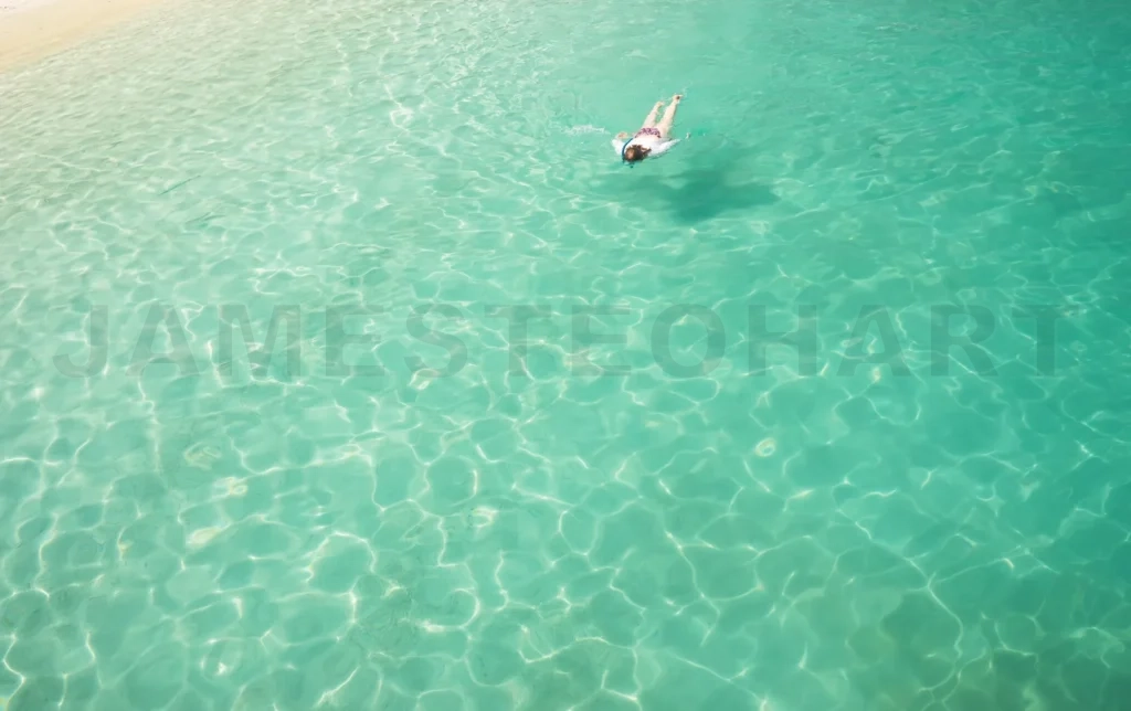 
Woman snorkeling in clear turquoise tropical water